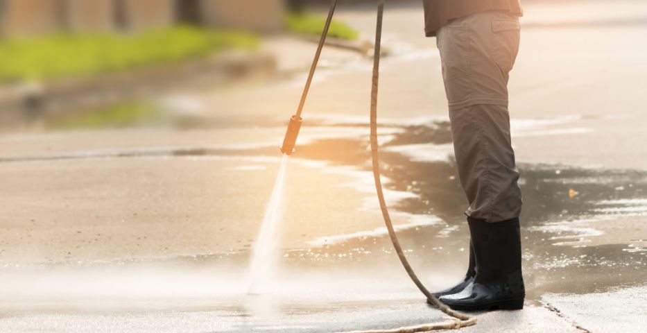 man power washing a walkway